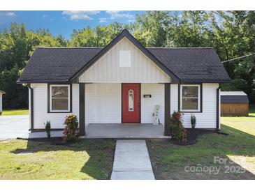 Charming one-story home featuring a red front door, black roof, and a well-manicured lawn at 803 Irene Ave, Kannapolis, NC 28083