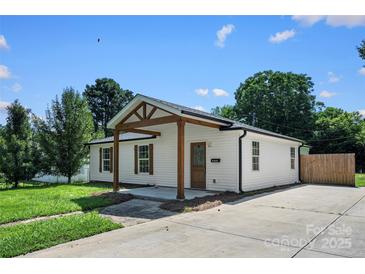 Charming single-story home featuring a covered porch with timber beams and a spacious concrete driveway at 1122 Oconee Ave, Rock Hill, SC 29732