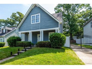 Charming blue two-story home with a well-maintained front yard and a gated driveway at 1226 Rising Oak Dr, Charlotte, NC 28206
