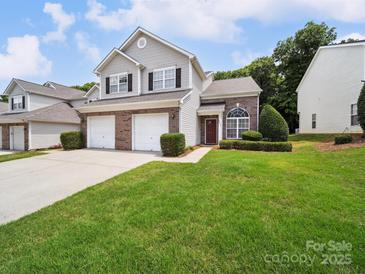 Two-story townhome featuring a well-maintained lawn and a two-car garage at 12415 Stratfield Place Cir, Pineville, NC 28134