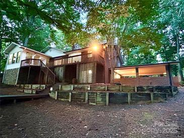 Beautiful exterior with wooden deck, brick features, and lush surrounding trees at 143 Uwharrie Ct # 10801081, Mount Gilead, NC 27306