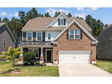 Charming two-story home featuring a brick and siding exterior, a well-manicured lawn, and an attached two-car garage at 169 Rooster Tail Ln, Troutman, NC 28166