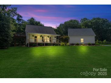 Charming exterior of a well-maintained home with a large yard and separate garage at 220 Plonk Rd, Dallas, NC 28034