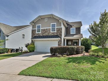Charming two-story home features a manicured lawn, stone accents, and a two-car garage at 3009 Canopy Dr, Indian Trail, NC 28079
