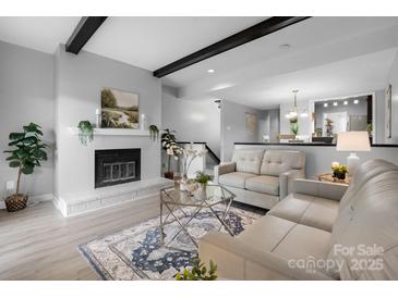 Cozy living room features a fireplace, wood beams, and an open layout to the dining area at 5192 Corbin Ln, Hickory, NC 28601