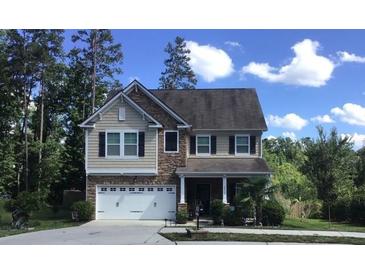 Charming two-story home with stone and siding accents, a two-car garage, and professionally landscaped yard at 6412 Bluegill Rd, Charlotte, NC 28216