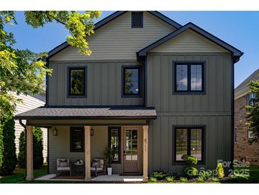 Charming two-story home features a welcoming front porch with stylish seating area and manicured landscaping at 6711 Creft Cir, Lake Park, NC 28079