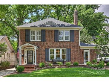 Charming brick home with black shutters, a well-manicured lawn, and a welcoming front porch and walkway at 726 E Kingston Ave, Charlotte, NC 28203