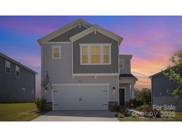 Charming two-story home with a two-car garage and manicured landscaping against a vibrant sunset at 1010 Harry Ct, Albemarle, NC 28001