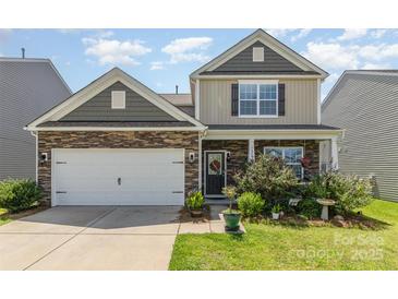 Charming home with a stone and siding exterior, a well-manicured lawn, and a cozy front porch at 1220 Kent Downs Sw Ave, Concord, NC 28027