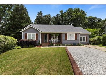 Charming home features a manicured lawn and inviting front porch with classic rocking chairs and wooden shutters at 1507 Breckenwood Dr, Rock Hill, SC 29732