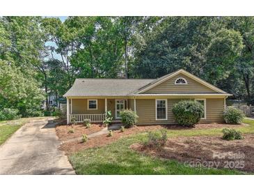 Charming single story home featuring a cozy front porch and mature trees at 2706 Bremer Ct, Charlotte, NC 28210