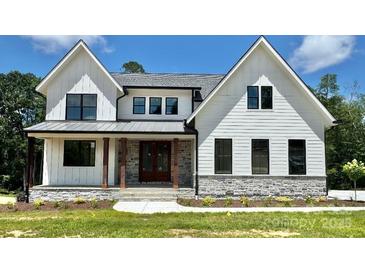 Charming two-story home with white siding, black trim windows, stone accents and covered front porch at 537 Riddle Mill Rd, Clover, SC 29710