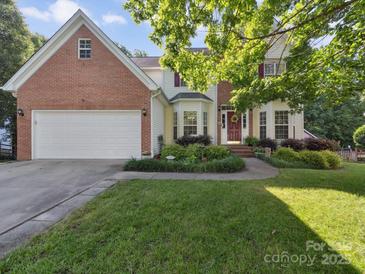 Charming two-story traditional-style home with a brick facade, attached garage, and manicured lawn at 130 Nims Spring Dr, Fort Mill, SC 29715