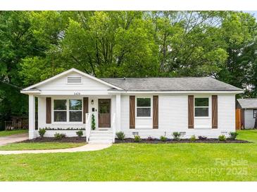 Charming single-story home featuring a well-maintained lawn and beautifully painted white brick at 1426 Larkfield Ln, Charlotte, NC 28210