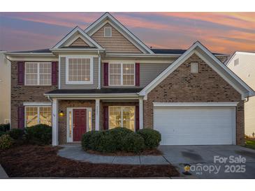 Charming two-story home features a brick and siding exterior, a two-car garage, and a well-manicured lawn at 5805 Lindley Crescent Dr, Indian Trail, NC 28079
