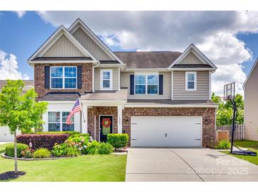 Charming two-story home with brick accents, a landscaped yard, and a two-car garage at 6243 Kilchurn Dr, Indian Land, SC 29707