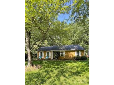 Charming home featuring a well-maintained yard, complemented by mature trees and quaint white shutters at 6832 Delta Lake Dr, Charlotte, NC 28215