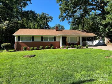 Charming one-story home with a brick facade, well-manicured lawn, and mature trees in a peaceful setting at 708 East St # 89, Albemarle, NC 28001