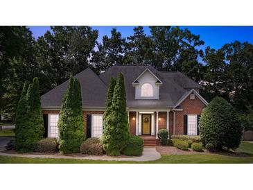 Charming brick home with a well-manicured lawn, mature trees, and a welcoming front porch at 803 Woodmoore Ln, Kannapolis, NC 28081