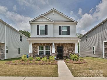 Charming two-story home featuring a brick facade, a covered porch, and black window shutters at 835 Windage Way, Pineville, NC 28134