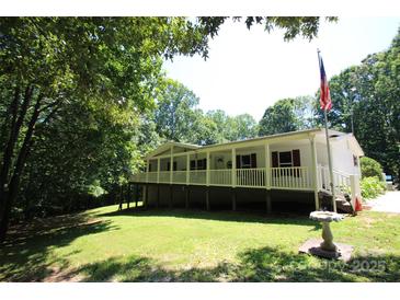 Inviting exterior of a white raised home with a wrap-around porch and a lush green lawn at 220 Singing Pine Dr, Clover, SC 29710