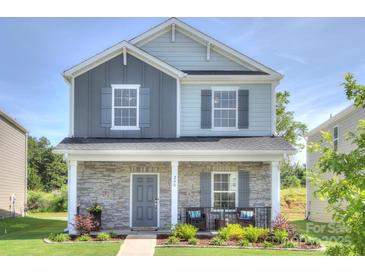 Charming two-story home with stone accents, inviting front porch, and well-maintained landscaping at 240 Orson Oaks Ln, Pineville, NC 28134
