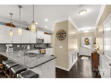 Bright eat-in kitchen features granite counters, stainless appliances, pendant lighting and dark hardwood floors at 515 Stickley Pl, Lancaster, SC 29720