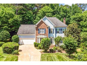 Charming two-story home featuring a well-manicured lawn, brick accents, and a two-car garage at 5238 Downing Creek Dr, Charlotte, NC 28269