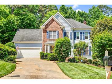 Charming two-story home featuring a well-manicured lawn, brick accents, and a two-car garage at 5238 Downing Creek Dr, Charlotte, NC 28269