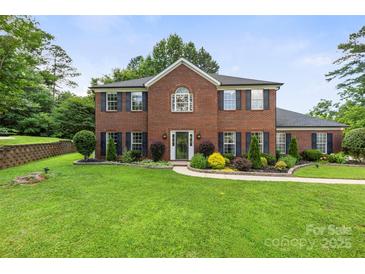 Charming brick home with manicured lawn, dark shutters, and inviting front entrance at 5302 Fairgrove Ln, Harrisburg, NC 28075