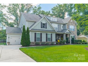 Beautiful two-story home with stone accents, manicured lawn, and attached two-car garage at 6417 Loyola Ct, Mint Hill, NC 28227