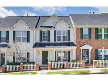 Charming townhome with white siding, black shutters, and a well-manicured lawn and picket fence at 764 Atherton Way, Rock Hill, SC 29730