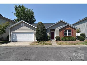Charming single-story home with a well-manicured lawn and a cozy red front door, complemented by a two-car garage at 8655 Meadowmont View Dr, Charlotte, NC 28269