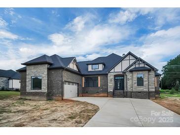 Beautiful single-Gathering home featuring stone and brick accents, a gray roof, and a three-car garage at 106 Kelly Marie Ct, Kings Mountain, NC 28086