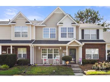 Charming townhome with rocking chairs on the porch, landscaped yard, and inviting curb appeal at 11023 Kinston Ridge Pl, Charlotte, NC 28273