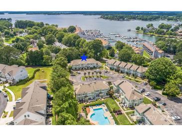 Beautiful aerial view of a condo community by the lake with a pool, green spaces, and boat harbor at 17431 Tuscany Ln, Cornelius, NC 28031