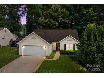 Charming single-story home boasts an attached garage and a well-manicured lawn at 5221 Javitz Rd, Charlotte, NC 28216