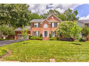 Charming two-story brick home featuring a well-manicured lawn and mature landscaping at 5610 Monticello Nw Dr, Concord, NC 28027