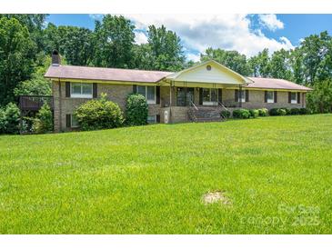 Charming brick home featuring a large front yard with mature trees and welcoming front porch at 5635 Highway 55 E Hwy, Clover, SC 29710