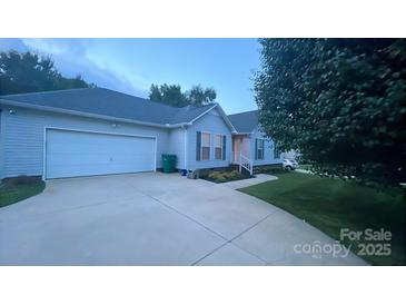 Charming home with a well-manicured lawn and a long driveway leading to an attached two-car garage at 614 W Peeler St, Salisbury, NC 28146