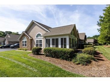 Attractive home exterior featuring stone accents, a well-maintained lawn, and manicured landscaping at 6811 Ledgestone Pl, Charlotte, NC 28227
