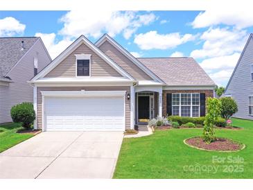Charming single-Gathering home featuring a two-car garage, manicured lawn, and inviting front porch at 8409 Darcy Hopkins Dr, Charlotte, NC 28277