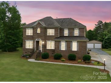 Charming brick two-story home with a well-manicured lawn and traditional architectural details at 9450 Surface Hill Rd, Mint Hill, NC 28227