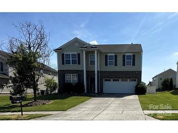 Charming two-story home featuring a manicured lawn and attached two-car garage at 1007 Green Terra Rd, Indian Trail, NC 28079