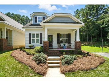 Charming home featuring a cozy front porch, well-maintained landscaping, and classic architectural details at 11359 Deer Ridge Ln, Charlotte, NC 28277