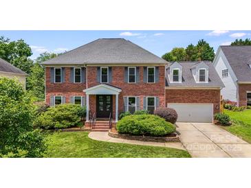 Charming two-story brick home with a well-manicured lawn and attractive landscaping at 12416 Stirling Trace Ct, Charlotte, NC 28277