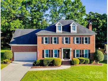 Beautiful two-story brick home with manicured lawn, mature trees and traditional architectural details at 12434 Sylvan Oak Way, Charlotte, NC 28273