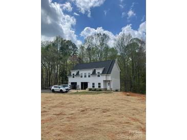 Charming two-story home with a grey exterior, black roof, and a spacious two-car garage on a sprawling lot at 237 Mariposa Rd, Stanley, NC 28164
