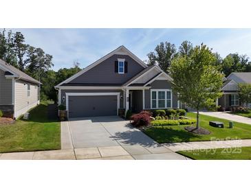Charming single-Gathering home features a manicured lawn, gray siding and an attached two-car garage at 320 Secretariat Dr, Iron Station, NC 28080